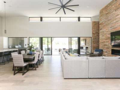 Adjoining Kitchen Living Room Seating Wood Floors High Ceiling Dining Table Modern Fireplace Decorative Pendants Elite Cabinets Tulsa Cabinet Designers